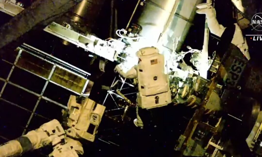 Spacewalking astronauts install an International Space Station roll-out solar array